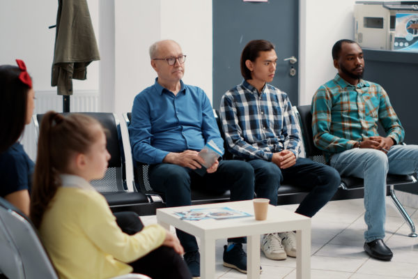 Diverse group of people sitting together in hospital waiting room